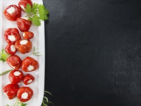 Filled Pimientos on a vintage slate slab (close-up shot, selective focus)