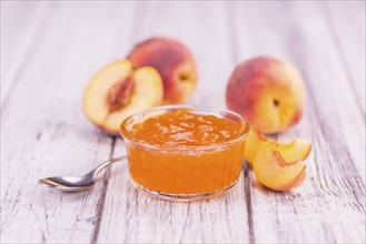 Peach Jam on an old wooden table as detailed close-up shot, selective focus