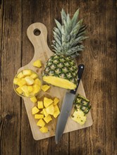 Sliced Pineapple on rustic wooden background as close-up shot