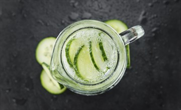 Portion of Cucumber Water as detailed close up shot on a slate slab, selective focus