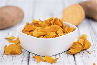 Homemade Sweet Potato Chips on vintage background selective focus, close-up shot