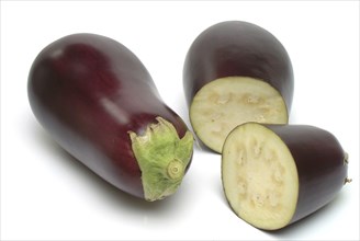 Aubergine, Solanum melongena, egg plant, single ripe fruit and halved fruit next to it