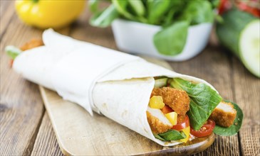 Chicken Wrap (detailed close-up shot, selective focus) on wooden background