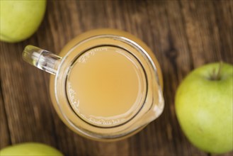 Apple Juice on an old wooden table as detailed close-up shot (selective focus)