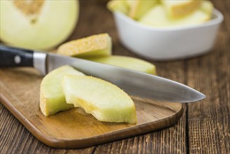 Honeydew Melon on an old wooden table as detailed close-up shot (selective focus)