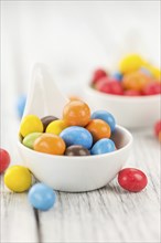 Cocolate coated Peanuts on a vintage background as detailed close-up shot (selective focus)