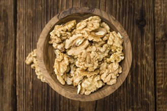 Walnuts (kernels) on an old wooden table as detailed close-up shot (selective focus)