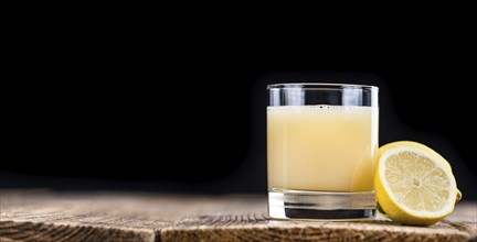 Fresh made Juice (lemon) on an old and rustic wooden table (selective focus, close-up shot)