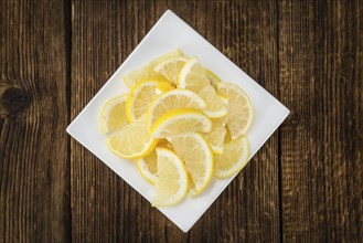 Homemade Lemon Slices on an wooden table (selective focus) as detailed close-up shot