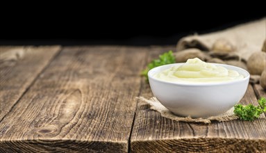 Portion of homemade Mashed Potatoes on wooden background (selective focus, close-up shot)