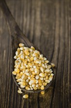 Portion of Corn (detailed close-up shot) on wooden background (selective focus)