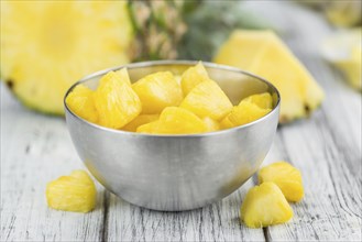 Sliced Pineapple on rustic wooden background as close-up shot