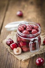 Preserved Cherries on an old wooden table as detailed close-up shot, selective focus