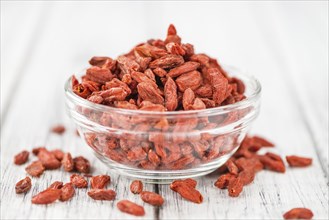 Goji Berries (dried) on an old wooden table as detailed close-up shot (selective focus)