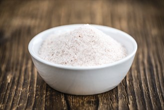 Himalayan Salt as high detailed close-up shot on a vintage wooden table (selective focus)