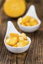 Kaki fruits on rustic wooden background (close-up shot)