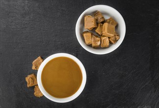 Caramel Sauce on a vintage slate slab (close-up shot, selective focus)