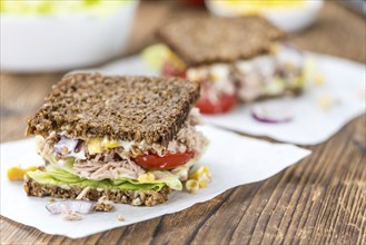 Old wooden table with Tuna sandwich (on wholemeal bread, selective focus)