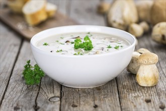 Porcini Soup on an old wooden table as detailed close-up shot, selective focus