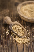 Mustard Seeds on rustic wooden background (close-up shot)