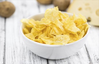 Cheese and Onion Potato Chips on rustic wooden background (close-up shot)
