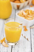 Portion of fresh made Tangerine Juice (close-up shot, selective focus)