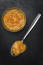 Portion of Apricot Jam on a rustic slate slab (selective focus, close-up shot)