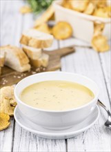 Creamy Chanterelle Soup on an old wooden table as detailed close-up shot, selective focus