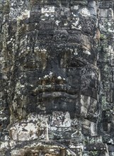 An ancient statue on top of a gate at Ankor Thom in Cambodia