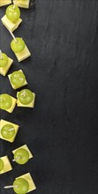 Cheese blocks with grapes as close-up shot on a vintage looking slate slab (selective focus,