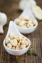 Marinated Garlic on an old wooden table as detailed close-up shot (selective focus)