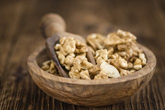 Walnuts (kernels) on an old wooden table as detailed close-up shot (selective focus)