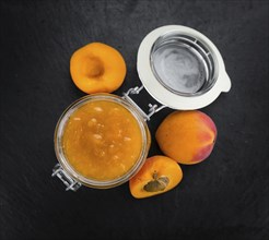 Portion of Apricot Jam as detailed close up shot on a slate slab (selective focus)