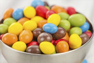 Cocolate coated Peanuts on an old wooden table as detailed close-up shot (selective focus)