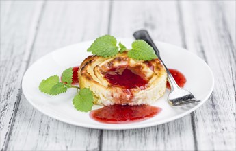 Cheesecake with Sauce on an old wooden table as detailed close-up shot (selective focus)