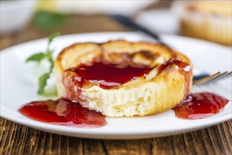 Cheesecake with berry Sacue on a vintage background as detailed close-up shot (selective focus)