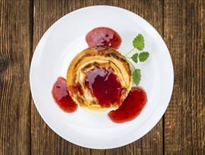 Cheesecake with Sauce on an old wooden table as detailed close-up shot (selective focus)