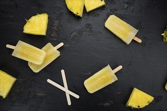 Fresh made Popsicles (Pineapple flavoured, selective focus) on a rustic background