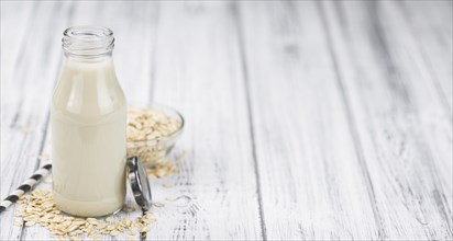 Healthy Oat Milk on a wooden table as detailed close-up shot (selective focus)