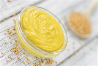 Portion of homemade Mustard on wooden background (selective focus, close-up shot)