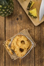 Pineapple rings (dried) on an old wooden table as detailed close-up shot, selective focus