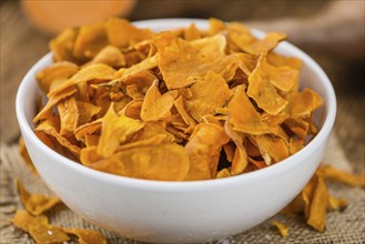 Sweet Potato Chips on a vintage background as detailed close-up shot, selective focus