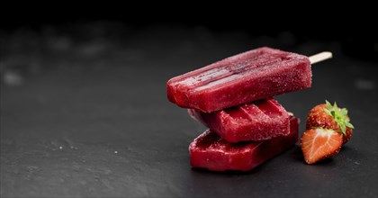 Strawberry Popsicles (close-up shot, selective focus) on a rustic background