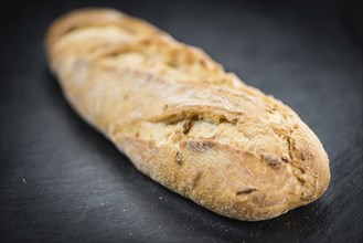 Baguette on a vintage slate slab (close-up shot, selective focus)