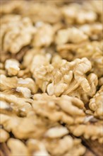 Walnuts (kernels) on an old wooden table as detailed close-up shot (selective focus)