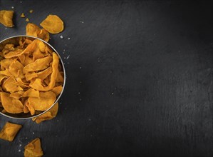 Some Sweet Potato Chips on a slate slab as detailed close-up shot, selective focus