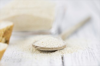 Wooden spoon with Breadcrumbs (close-up shot, selective focus) on an old wooden table