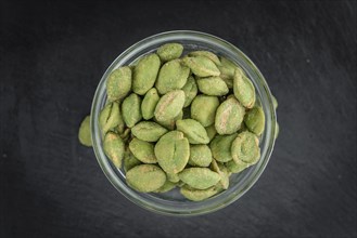 Some fresh Wasabi Peanuts on a vintage slate slab (selective focus, close-up shot)