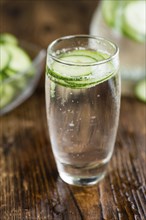 Cucumber Water on rustic wooden background as close-up shot