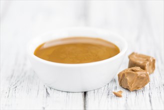 Caramel Sauce on a vintage background as detailed close-up shot (selective focus)